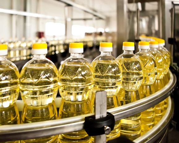 Sunflower oil in the bottle moving on production line.